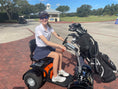 Load image into Gallery viewer, Discover Your Mobility Cheeta Ninja All Terrain Bariatric Scooter outdoors on rough terrain, showing its sturdy design and large wheels.
