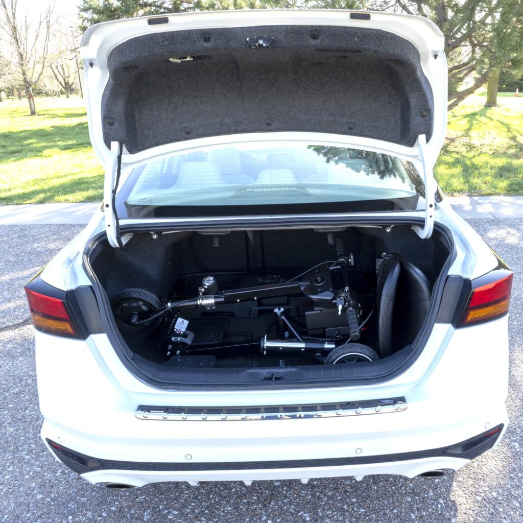 SNAPnGO Mobility Scooter Sport Edition USB stored in car trunk, compact foldable design for easy transport and storage.